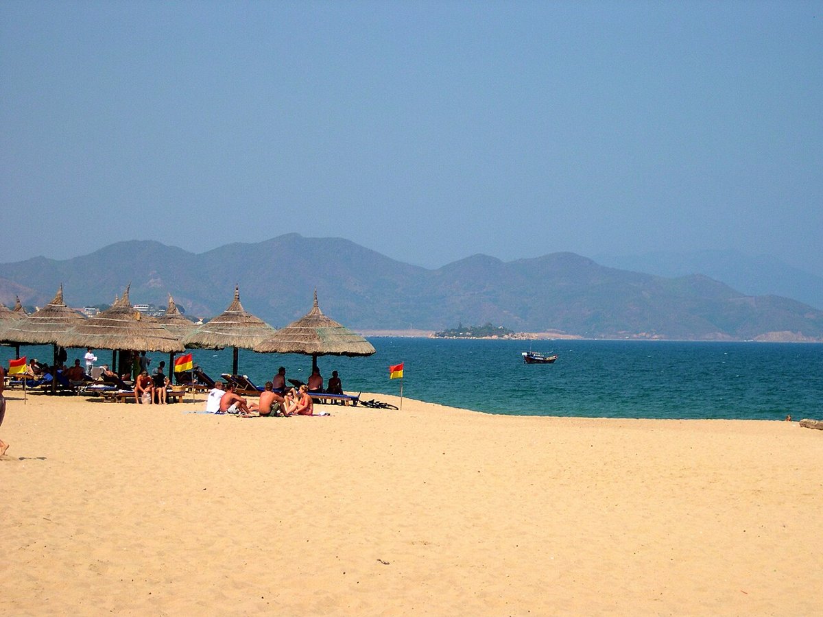 Bãi biển Nha Trang với hàng dù lá và núi xa – đầu đi của hành trình Nha Trang Cần Thơ