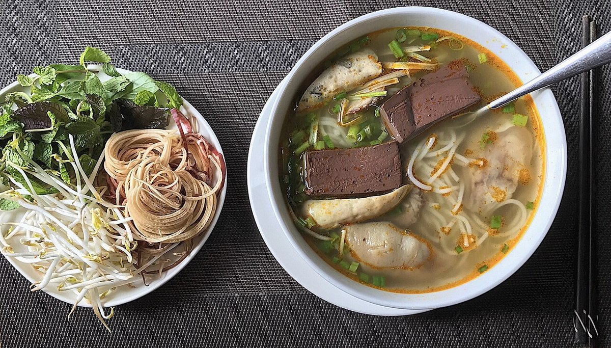 Tô bún bò Huế với chả cua, huyết và đĩa rau sống ăn kèm