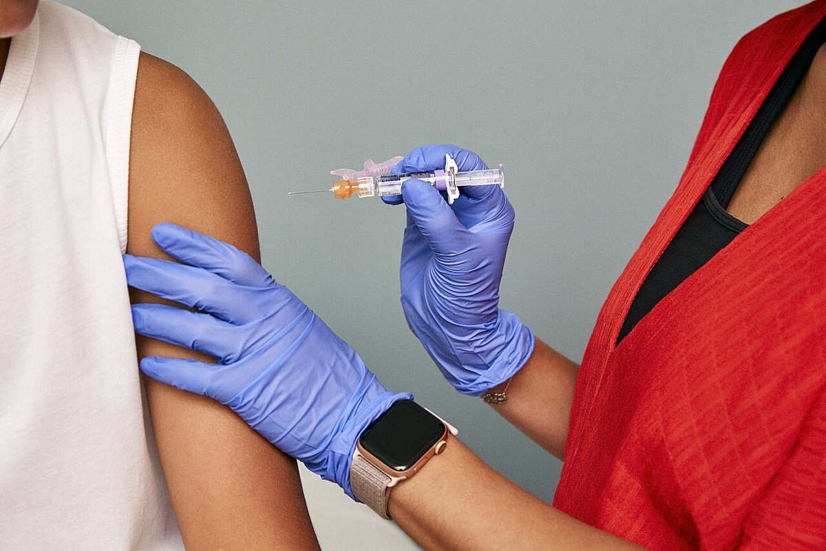 Nhân viên y tế tiêm vaccine vào cánh tay – tiêm phòng trước khi đi du lịch quốc tế